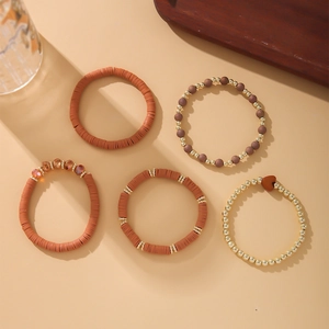 Detail of 5-piece Bohemian bracelet set with brown clay beads and golden heart charms