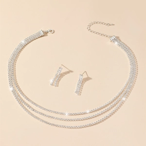 Detailed close-up of multi-layer silver rhinestone necklace and tassel earrings set
