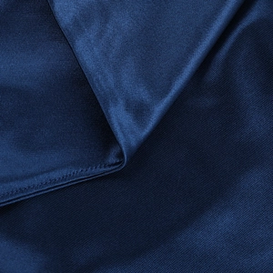 Macro shot of dark blue knit fabric showing refined texture and neat rolled hem stitching