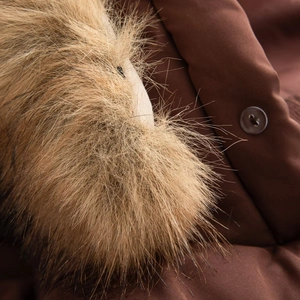 Detailed close-up of plush brown faux fur collar and durable hooded winter coat fabric