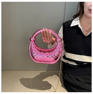 Detail view of hot pink acrylic tote with quilted pattern and thin gold chain strap