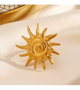 Macro view of sunburst gold ring with spiral center on luxury white silk fabric
