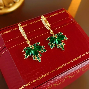 Detailaufnahme der grünen Ahornblatt-Ohrringe mit Zirkonia und Goldbeschichtung