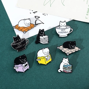 Macro detail of eight colorful enamel cat pins showing cats reading and sleeping