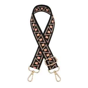 Detail of adjustable geometric woven bag strap with golden metal lobster clasps