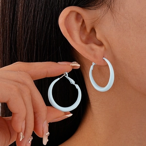 Close-up of light blue geometric hoop earring showing matte finish and ear-worn effect