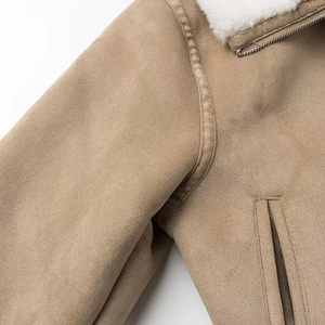 Détail de la veste en daim kaki avec col en fourrure blanche et fermeture éclair métal