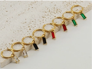 Détail de boucles d'oreilles en zircone or et argent sur support en pierre