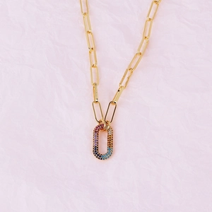 Detail of gold link chain necklace with rainbow cubic zirconia encrusted oval pendant