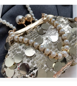 Macro detail of champagne gold sequin clutch with large pearl handle and metal clasp