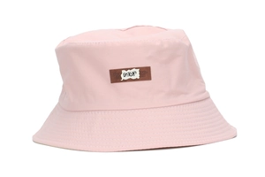 Detailed view of pink bucket hat featuring a brown leather patch with artistic embroidery