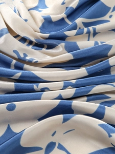 Macro shot of silk scarf showing glossy blue and white floral pattern texture