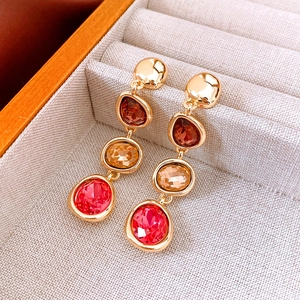Macro view of vintage gold flower earrings with three-tier multicolor crystal gemstones