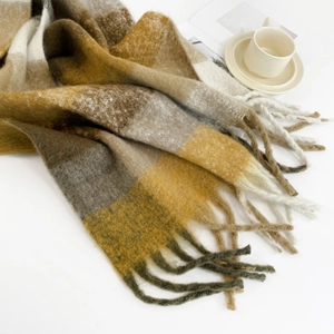 Detail of yellow and brown checkered mohair scarf with soft fringe texture and warm style