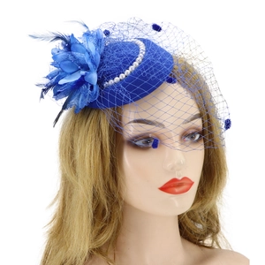 Detail of blue fascinator hat featuring elegant feathers, pearls, and a delicate mesh veil