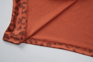 Gros plan sur le tissu léopard montrant la texture brun-rouge et la couture à double aiguille
