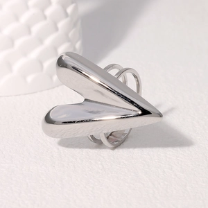 Macro detail of high-polish silver stainless steel heart-shaped ring on white texture