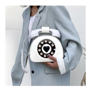 Detailed close-up of a vintage-style rotary telephone bag in white faux leather