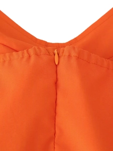 Détail de la robe orange montrant la fermeture éclair invisible de haute qualité au dos