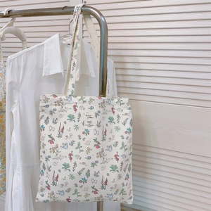 Detail of canvas tote bag with floral animal print and rectangular woven label