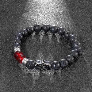 Detailed macro view of black volcanic lava beads and silver Hamsa Hand charm on a beaded bracelet