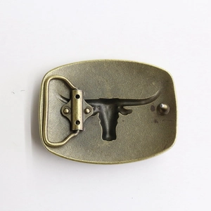 Close-up of retro golden bull skull belt buckle with detailed western cowboy relief