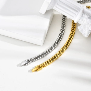 Détail de bracelets gourmettes en or et argent polis sur des supports en marbre