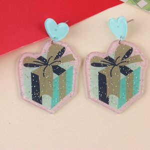 Macro view of heart-shaped acrylic earrings with pink glitter and gift box pattern