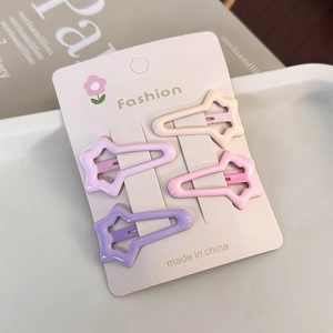 Detail of four star-shaped cream hair clips in assorted colors on display card