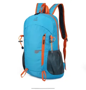 Detail of blue foldable hiking backpack with orange zipper accents and side mesh pocket