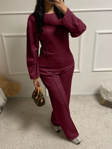 Detail of burgundy PU leather two-piece set featuring long sleeve top and trousers