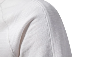 Detailed close-up of premium white knit sweatshirt showing precise shoulder seam stitching