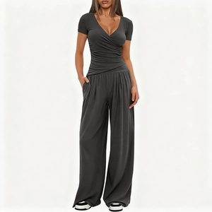 Detail of dark grey V-neck wrap top and high waist wide leg pants with side pockets