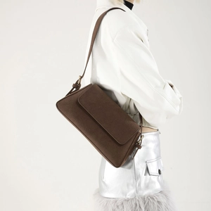 Brown retro suede baguette shoulder bag shown on model with stylish winter outfit