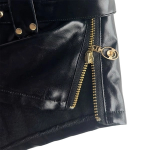 Nahaufnahme der schwarzen PU-Ledershorts mit goldenem Reißverschluss und Nieten-Details