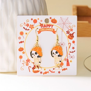 Detail of Halloween skull earrings with orange hats and gold-tone hooks on card
