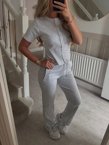 Detail view of a gray two-piece set with a buttoned short-sleeve top and joggers