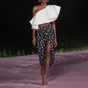 Chic two-piece set with white off-shoulder ruffled top and black polka dot wrap skirt