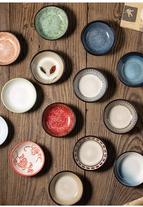 Vista dall'alto di piccole ciotole per salse in ceramica con motivi su legno rustico