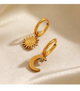 Macro view of gold hoop earrings featuring sun and moon pendants with delicate rhinestones