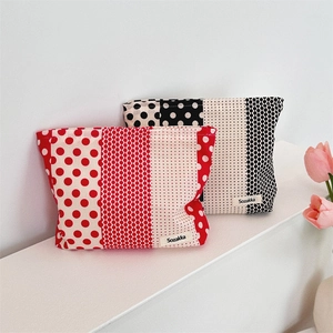 Macro detail of red and black polka dot fabric cosmetic bags with Sozakka labels
