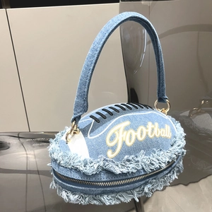 Macro shot of football-shaped denim clutch with frayed edges and embroidered football text