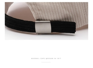 Detail of corduroy baseball cap back with black adjustable strap and matte silver buckle