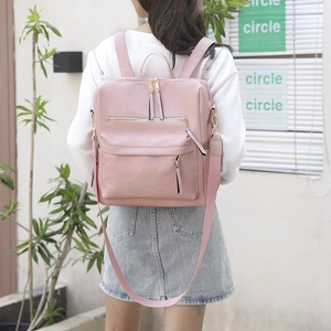 Rosafarbener Damen-Rucksack aus PU-Leder mit langen Fransen-Reißverschlüssen am Model
