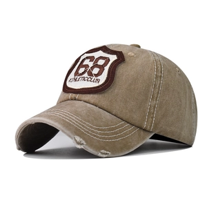 Detail of khaki washed cotton baseball cap with 68 athletic embroidery and distressed brim