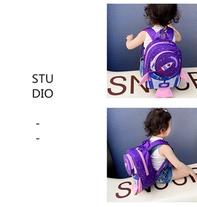 Detailed back view of children's rocket space backpack with safety leash and stars