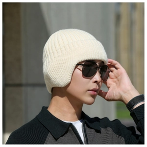 Detail of cream white ribbed knit earflap hat with thick textured winter lining