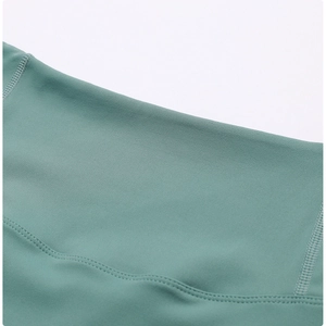 Detailed close-up of high-elastic grey-green yoga leggings with flatlock stitching