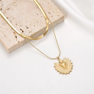 Double-layered gold snake chain necklace featuring a heart sunburst pendant on stone