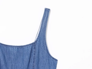 Dettaglio delle spalline e dello scollo di un abito in denim con cuciture doppie di pregio